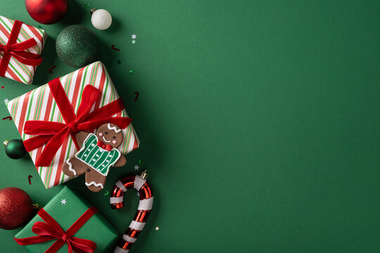 Festive Christmas presents with gingerbread cookie, candy cane and red bows on green background for Merry Christmas and Happy New Year