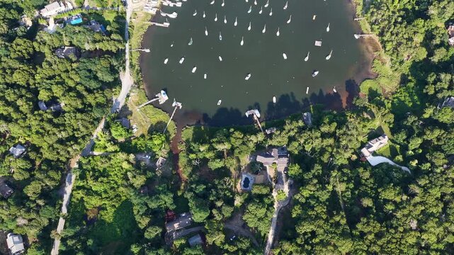 Healthy forest and marsh surrounds the scenic Arey's Pond in Orleans, Cape Cod, MA. This area of New England is a perfect area for sailboats during the warm summer months.