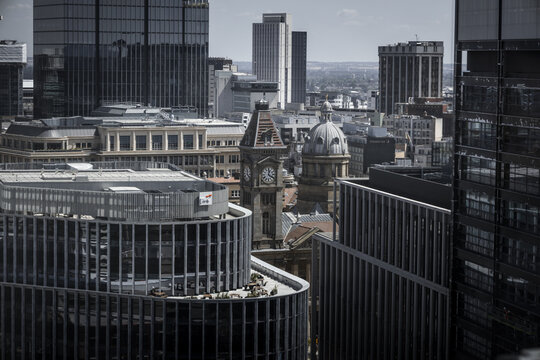 Aerial view of the historic Council House clock tower surrounded by modern glass skyscrapers and urban architecture in Birmingham, England, United Kingdom.