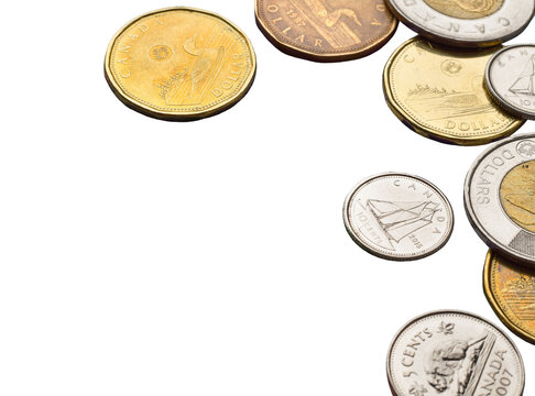 Various Canadian coins including loonie, toonie, quarter, dime and nickel scattered and framing right side of transparent background with copy space