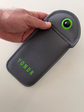 Person holding a Yondr Phone Locking Pouch for Device-Free Events