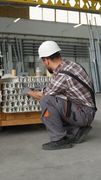 Warehouse worker managing stacked aluminum profiles