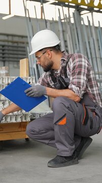 Warehouse worker inspecting and counting inventory on a pallet