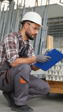 Warehouse worker inspecting inventory and checking clipboard list