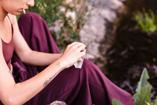 Young woman rolling a cannabis joint outdoors