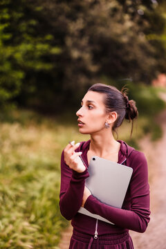 Young hispanic woman smoking a hand-rolled tobacco or joint holding tablet