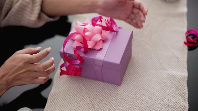Mother and daughter decorating a purple gift box together