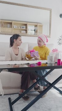 Daughter giving a handmade gift to mother with cancer
