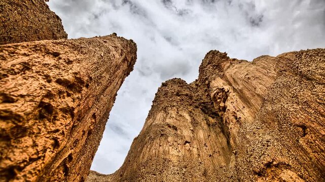 Timelapse looking up at the Bosnian Sand Pyramids showcasing impressive natural sandstone rock formations and dramatic moving clouds in Bosnia and Herzegovina.