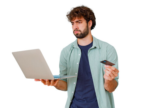 Frustrated man holding credit card and laptop, experiencing online shopping financial problems or unexpected debt