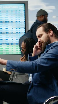 Vertical frame: Burned-out businessman suffers a migraine during an airport work trip, showing pain, overload and emotional detachment before a company event abroad.
