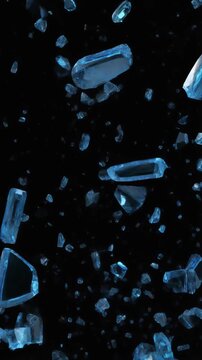 Blue glass shards shattering in slow motion on black background