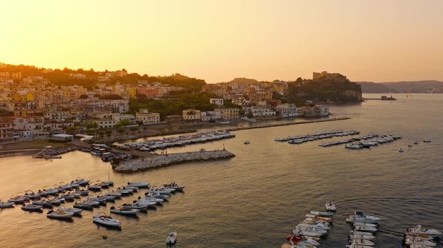 Dronata sul golfo di Bacoli con il porto e le barche fino al castello aragonese di Baia, nei Campi Flegrei al tramonto