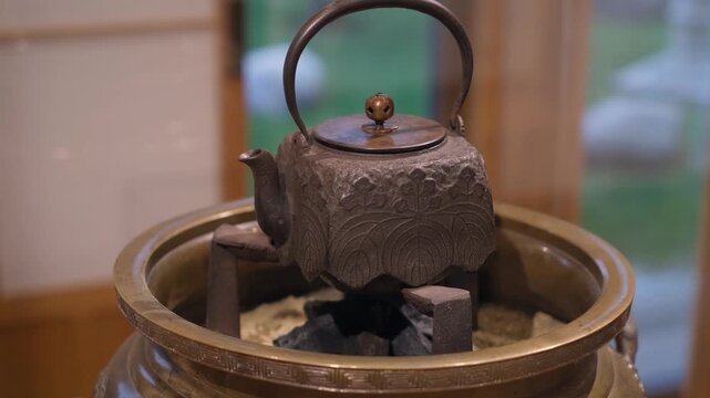 Vintage japanese tetsubin tea kettle on sand fire pit