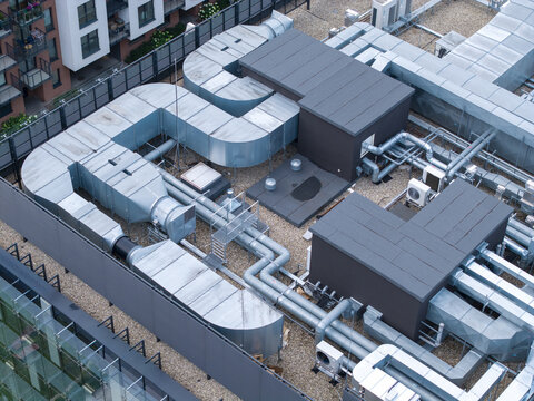 Aerial view of industrial cooling system and HVAC ductwork installed on a building rooftop in Krakow, Lesser Poland Voivode, Poland.