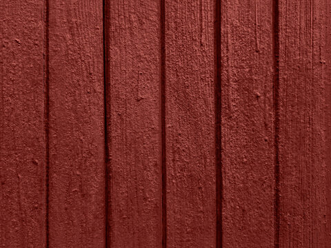 Old painted wooden door texture in barn red with vertical grooves weathered rustic surface detailed background natural grain vintage wall pattern seamless backdrop