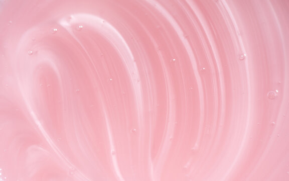 Pearlescent pink liquid soap, shower gel swirl texture, surface of liquid fluid, background, shampoo texture, body care cosmetic, texture of liquid washing gel, soap backdrop top view, from above