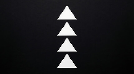 Fototapeta premium Triangles stacked in a vertical line create a rhythmic pattern against a black surface.