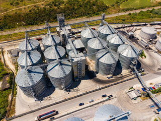 Storage silos and transport system at a grain facility in a rural area with a railway line nearby © DSMT