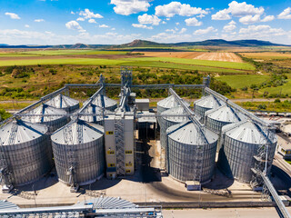 Modern storage facility with silos and open fields in the background on a sunny day © DSMT