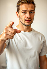 Fototapeta premium Serious young man pointing finger directly at camera, selection and accusation concept, recruitment and choice