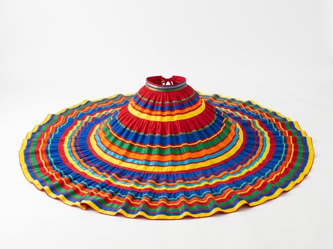 Vibrant Mexican folk skirt with colorful striped pattern and ruffled hem spread on the floor