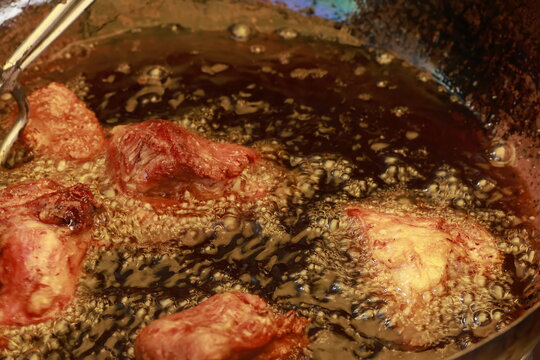 Pork meat cooking in hot lard for traditional Peruvian chicharr&oacute;n