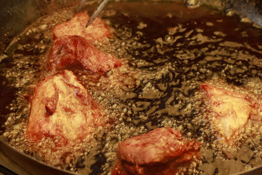 Pork meat cooking in hot lard for traditional Peruvian chicharr&oacute;n