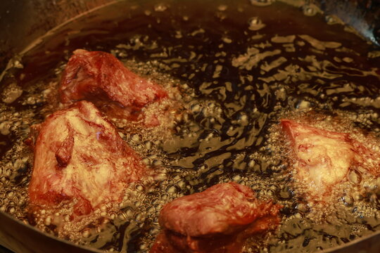 Pork meat cooking in hot lard for traditional Peruvian chicharr&oacute;n