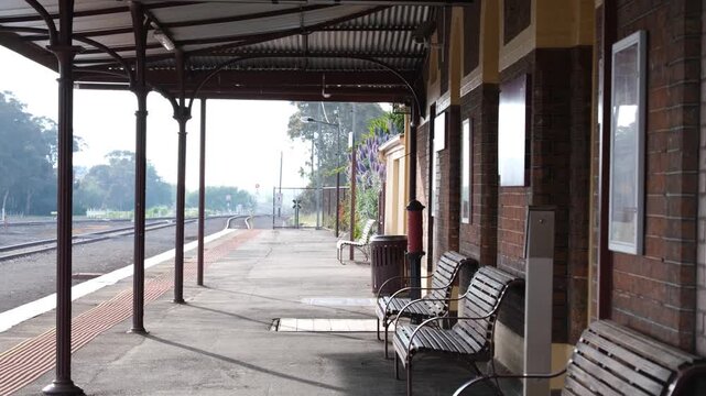 A covered platform with cast iron posts and a corrugated iron canopy running alongside a heritage brick station building.&nbsp;Historic Camperdown railway station in regional Victoria, Australia.