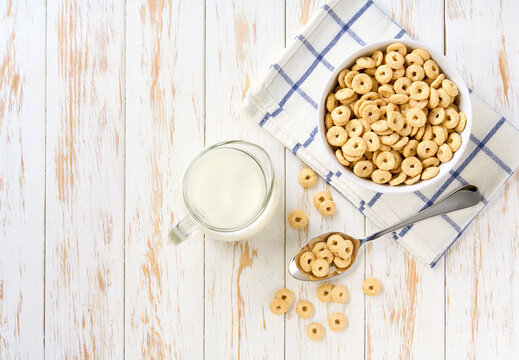 Quick breakfast for kids: corn hoops with milk  on table. Dry breakfast.