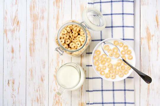 Healthy breakfast, bowl of corn rings with milk . Top view.
