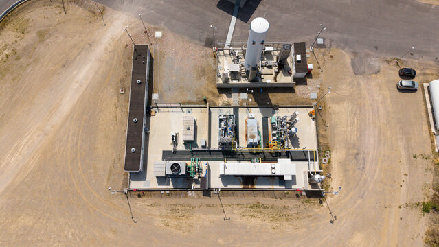 Aerial view of a modern biomethane production facility with storage tanks, processing units, and a fueling station in Tavazzano con Villavesco, Lombardy, Italy.