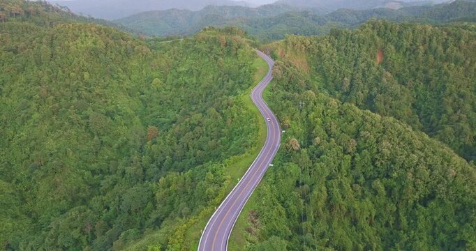 Aerial view of the legendary number three curve road in Nan, a scenic mountain highway known for its dramatic serpentine bends surrounded by green forest and panoramic landscapes.