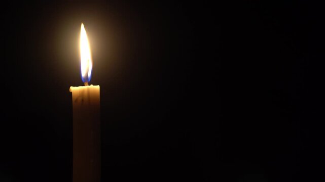 Calm Candlelight Flame Burning Quietly against Black Background
