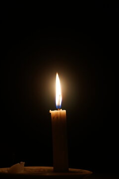 Close up of Burning Candle Flame in the Dark with Large Copy Space