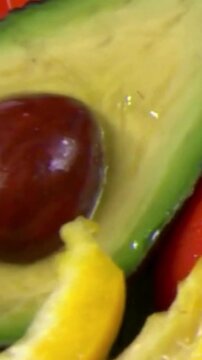 Fresh Halved Avocado with Seed and Orange Background