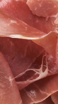 Fresh slices of delicious Italian prosciutto crudo meat