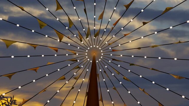 Central pole and radial strings holding lights and pennant flags, breeze causing fluttering at dusk
