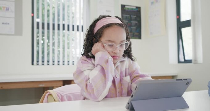 African American child student resting head, glancing, tapping tablet in folio, scrolling in class