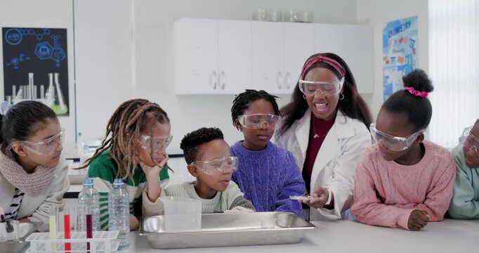 African American teacher teaching in lab, spooning white powder into tray as six children watching