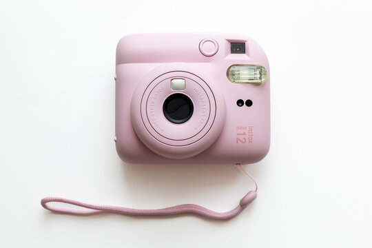 Moscow, Russia - 10.06.2025: The pink Fujifilm Instax mini 12 instant camera over white background. Photography enthusiasts, capturing memories, and creative projects