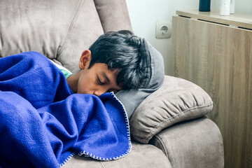 Closeup of an Exhausted Young Teenager Sleeping Peacefully on Living Room Sofa © Gatot