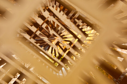 An abstract, close-up shot of a complex, laser-cut geometric design made from wooden panels