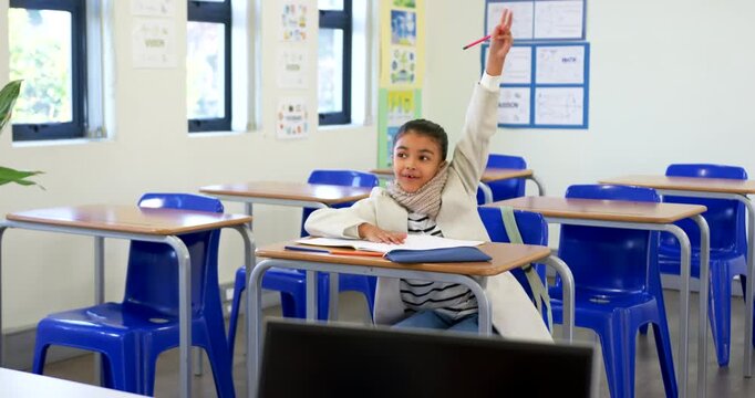 African American girl writing in classroom raising red pencil to answer cue then resuming writing