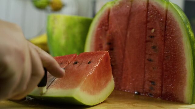 Cutting juicy watermelon into smaller slices in slow motion