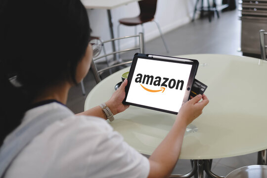 Bangkok, Thailand. July 29, 2026; A person holds a digital tablet displaying the Amazon logo alongside a credit card for online shopping.