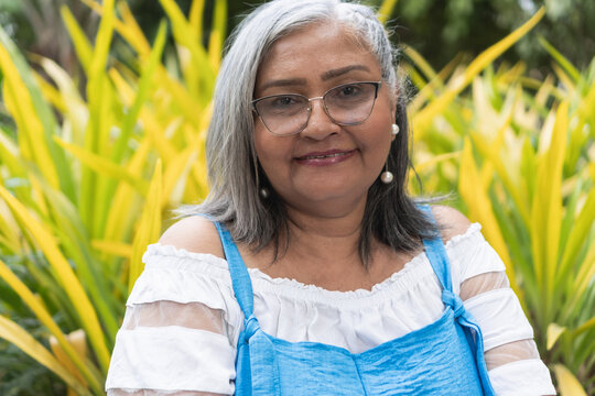 Smiling mature woman with grey hair wearing glasses