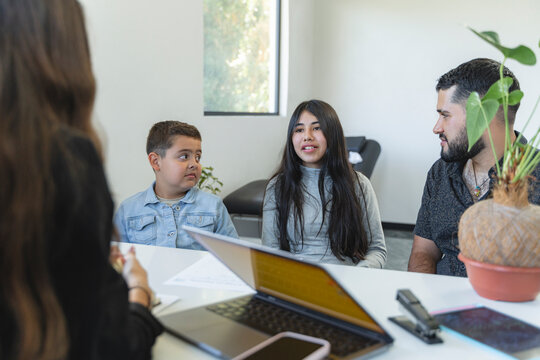 Hispanic family receiving family therapy from a female counselor