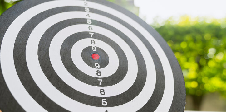 Dartboard stands tall and get someone skilled to throw darts, concept for business target planning growth and aim to winner goal.